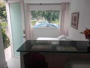 a glass table in a room with a view of a car at Monterrico Suites Hotel in Lima