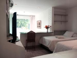 1 dormitorio con 2 camas, escritorio y ventana en Monterrico Suites Hotel, en Lima