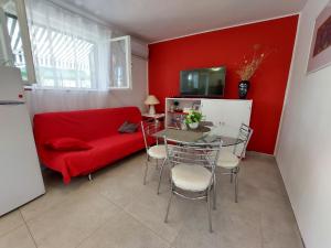 - un salon avec un canapé rouge et une table dans l'établissement Holiday home Vlasta - near sea, à Primošten