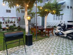 un patio con una mesa, una motocicleta y una lámpara en Villa homestay Misa, en Phan Thiet