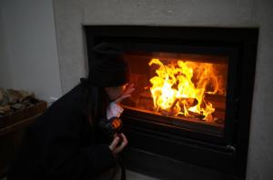 a woman is sitting in front of a fireplace at Hantang Inn Hostel Xi'an in Xi'an