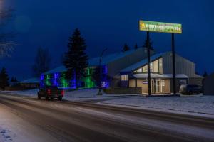 a building with a street sign at night at Northern Lights Inn in Fort Saint John
