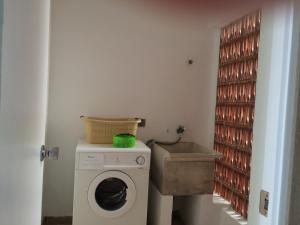 a laundry room with a washing machine and a sink at Apartamentos Serenity in Peniscola