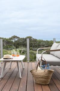 un patio con mesa, sofá y mesa en The Glasshouse, en Saint Andrews Beach