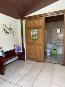 a bathroom with a toilet and a wooden door at Cottage Private Ensuite #2 in Monteverde Costa Rica
