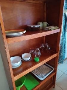 ein Holzregal mit Geschirr und Gläsern darauf in der Unterkunft Kiwi House in Monteverde Costa Rica