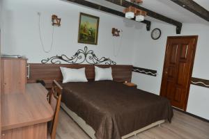 a bedroom with a bed with a wooden headboard at Pensiunea Butoias Glodeni in Glodeni