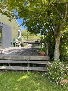 a wooden deck with a table and a tree at Rainbow Mountain cottage in Rotorua