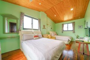 a bedroom with a large white bed and a wooden ceiling at Yilan My House Homestay B&B in Dayin