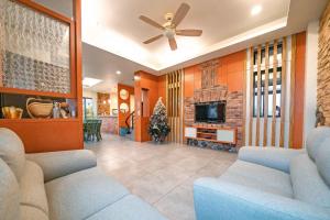 a living room with couches and a ceiling fan at Yilan My House Homestay B&B in Dayin