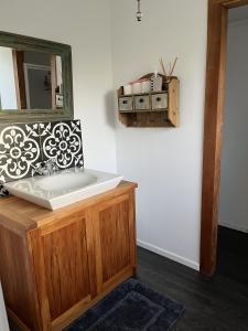 a bathroom with a sink and a mirror on the wall at Rainbow Mountain cottage in Rotorua