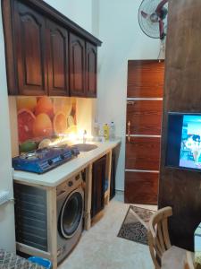 a kitchen with a sink and a washing machine at Youth Palace Hostel هوستل قصر الشباب in Alexandria