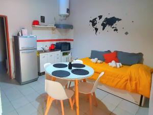a kitchen with a table and a bed with a map on the wall at APART CENTRO RIOJA, Zona Residencial, Parking privado gratis a 100 mts in Mendoza