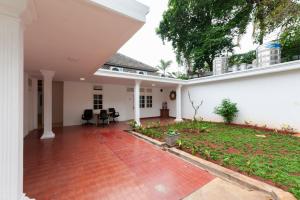 cortile aperto di una casa bianca con patio di RedDoorz @ Kemang Dalam a Giacarta