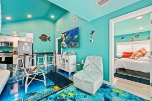 a bedroom with blue walls and a bed and a kitchen at Above The Sea in St. Petersburg