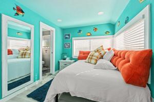 a blue bedroom with a bed with an orange headboard at Above The Sea in St. Petersburg