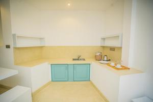 una pequeña cocina con armarios azules y paredes blancas. en Greencliff Mirissa, en Mirissa