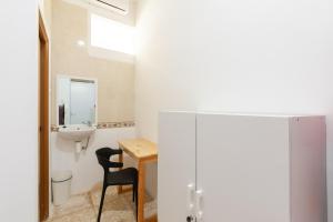 bagno con lavandino, scrivania e sedia di RedDoorz @ Kemang Dalam a Giacarta