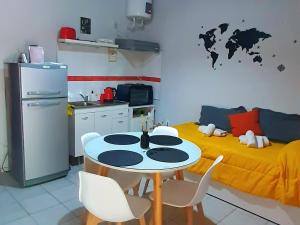 een keuken met een tafel en een geel bed bij APART CENTRO RIOJA, Zona Residencial, Parking privado gratis a 100 mts in Mendoza