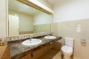 un bagno con due lavandini, un water e uno specchio di RedDoorz @ Kemang Dalam a Giacarta Altre 21 foto