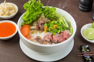 a bowl of soup with lettuce and meat and vegetables at Samnak Lounge in Siem Reap