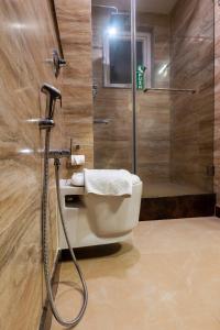 y baño con ducha, aseo y lavamanos. en Hotel Prism Jorhat, en Jorhāt