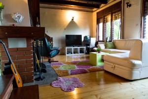 a living room with a couch and a tv at Holiday Home Ille in Netretić