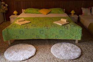 1 dormitorio con 1 cama verde con 2 alfombras en Holiday Home Ille en Netretić