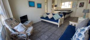 a living room with a blue couch and a piano at 703 High Tide, Holiday Apartment, Main Beach, Amanzimtoti in Amanzimtoti