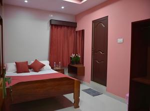 1 dormitorio con 1 cama con paredes de color rosa y puerta en Signature Stay, en Port Blair