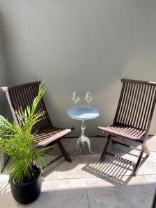 dwa krzesła i stół z dwoma kieliszkami wina w obiekcie Seaside Escape w mieście Sydney