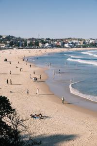 grupa ludzi na plaży blisko oceanu w obiekcie Seaside Escape w mieście Sydney