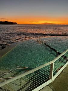 wanna z hydromasażem w środku wody o zachodzie słońca w obiekcie Seaside Escape w mieście Sydney