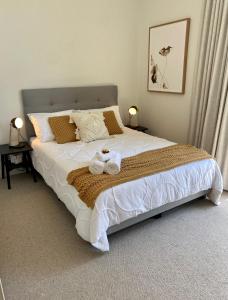sypialnia z dużym łóżkiem z dwoma ręcznikami w obiekcie Seaside Escape w mieście Sydney
