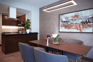 帕拉馬里博的住宿－Yogh Hospitality，一间带木桌和蓝色椅子的用餐室