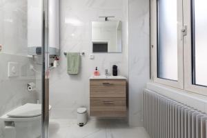 La salle de bains blanche est pourvue d'un lavabo et de toilettes. dans l'établissement La Maison de maître - centre historique - 3 rue henriette, à Mulhouse