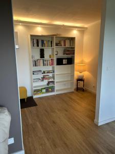 uma sala de estar com uma estante cheia de livros em Front de mer- Appartement standing 1 chambre em Calais