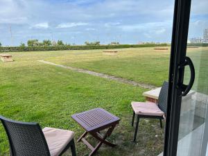 um pátio com cadeiras, uma mesa e um campo em Front de mer- Appartement standing 1 chambre em Calais