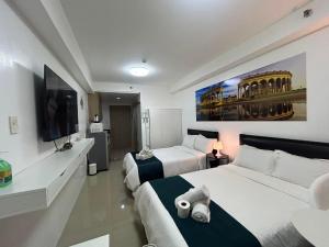 a hotel room with two beds and a flat screen tv at MOA Pasay 1156 Shore Residences Hotel Vibe Staycation in Manila