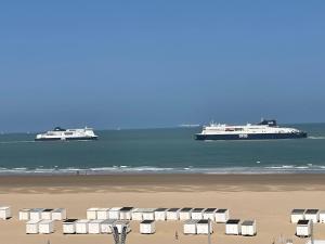 dos grandes barcos en el agua cerca de una playa en Front de mer- Appartement standing 1 chambre en Calais