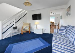 a living room with a couch and a tv at 139 Cae Du in Abersoch