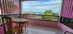 a balcony with a table and chairs and a view of the ocean at Puttaraksa kohlarn in Ko Larn