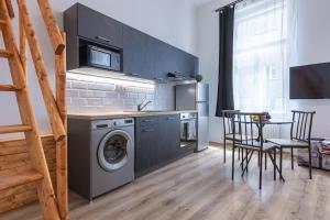 una cucina con lavatrice, tavolo e sedie di CHARLIE - modern centrally located downtown studio a Bratislava