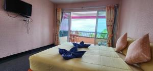 a bedroom with a large bed with blue bows on it at Puttaraksa kohlarn in Ko Larn