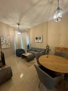 sala de estar con mesa y sofá en Marbella Grand Holiday Homes - Al Nahda 1 en Dubái