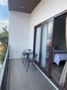 a balcony with a table and chairs and a bed at 44 Guest House Syariah in Purwokerto