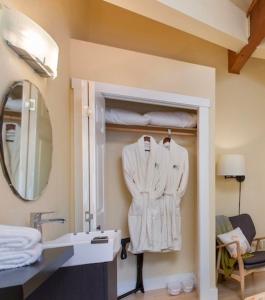 a bathroom with a sink and a white robe at Bell In The Woods B&B in Seward