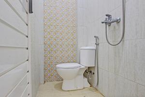 ein Bad mit einem WC und einer Dusche in der Unterkunft OYO 93253 Guest House Arundaya Syariah in Purwokerto