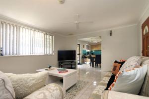 a living room with a couch and a tv at 4 Jacques Court in Bargara