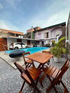 a patio with a table and chairs next to a pool at Residencial Napolitan in Manaus